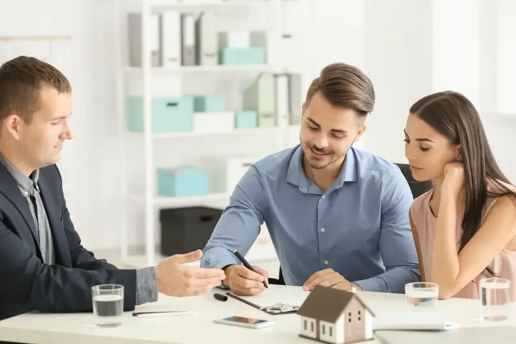 A Young Man Signs a Contract to buy a House With His Wife