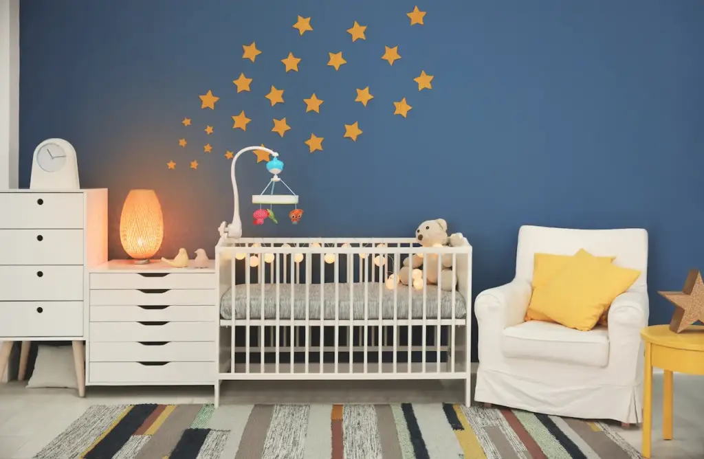 A Blue Baby Room Interior With A Comfortable Crib and Armchair