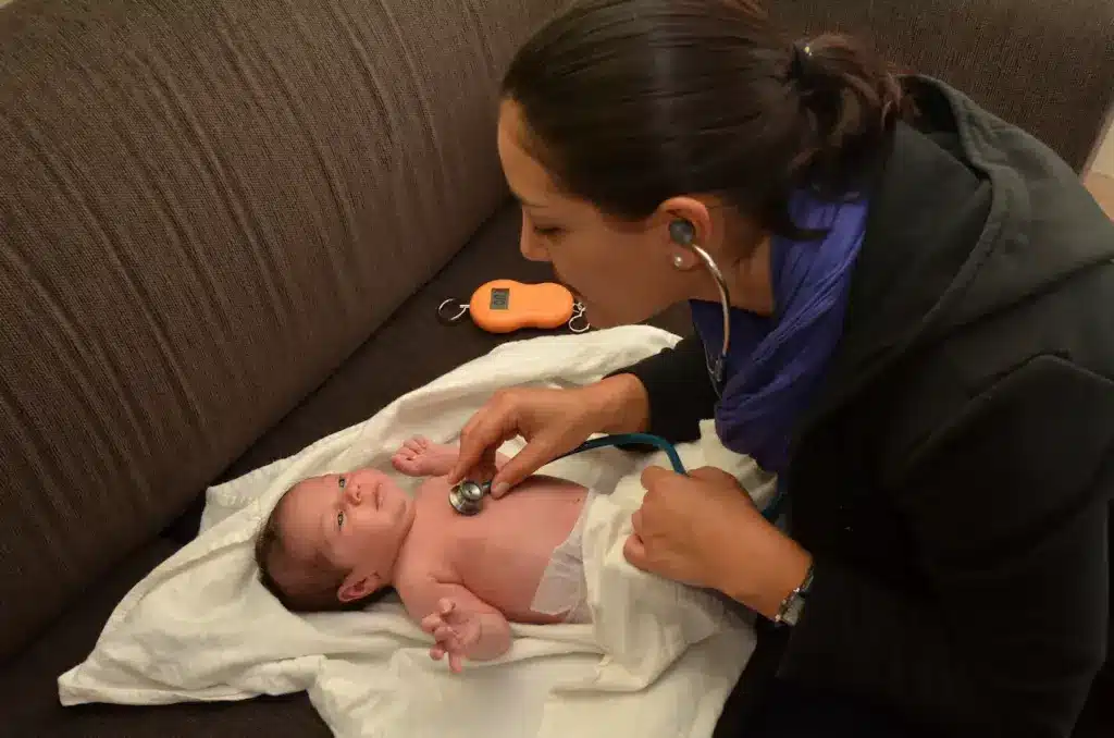 Midwife Checks the Newborn Baby's Heartbeat 